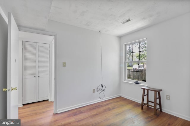 interior space featuring visible vents, baseboards, and wood finished floors