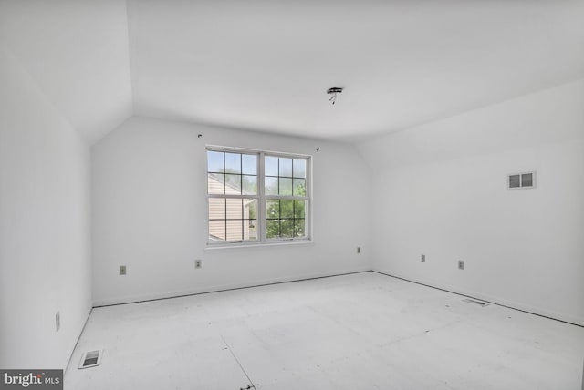 spare room with visible vents and lofted ceiling