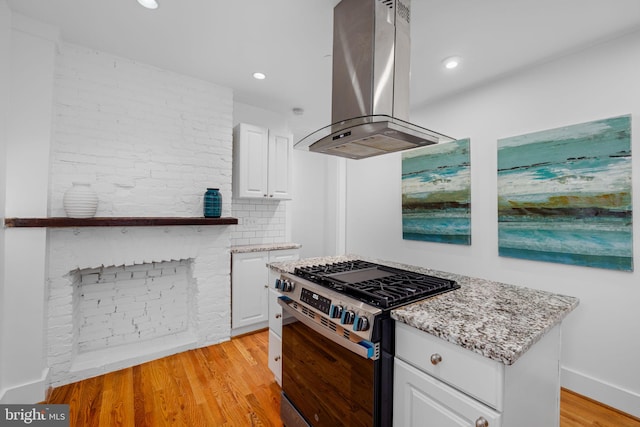 1524 5th St NW, Washington, DC 20001 - kitchen with white cabinetry, island range hood, gas range, and light stone countertops