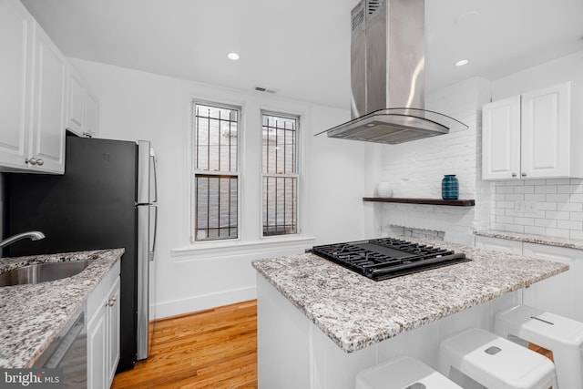 1524 5th St NW, Washington, DC 20001 - kitchen featuring exhaust hood, decorative backsplash, appliances with stainless steel finishes, a sink, and light wood finished floors