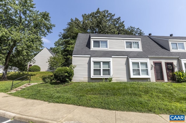 view of front of home with a front yard and roof with shingles