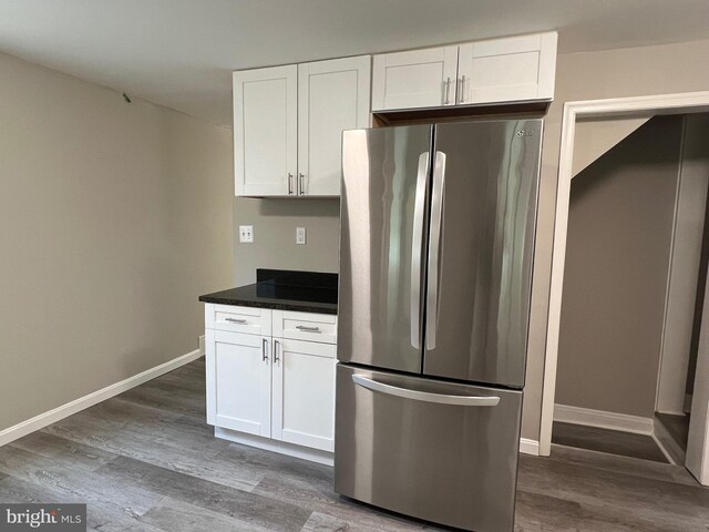 1948 Victory Dr, Baltimore, MD 21227 - kitchen with freestanding refrigerator, dark wood-style flooring, dark countertops, baseboards, and white cabinets