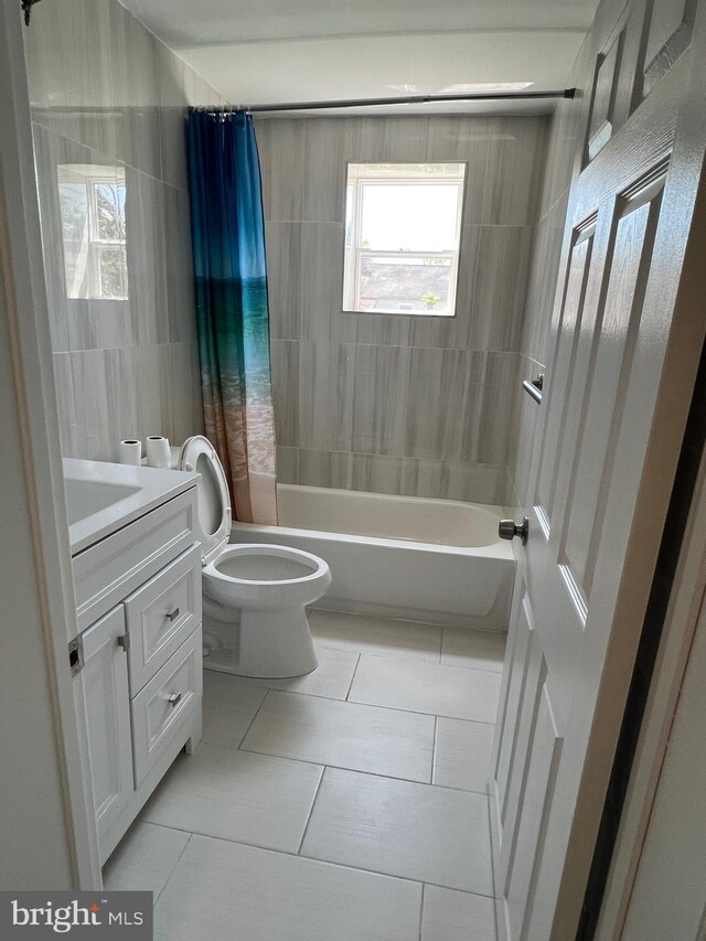 1948 Victory Dr, Baltimore, MD 21227 - bathroom with vanity, shower / tub combo with curtain, toilet, tile walls, and tile patterned floors
