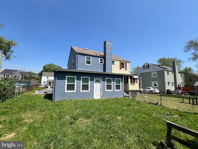 1948 Victory Dr, Baltimore, MD 21227 - back of house with a lawn, fence, and a chimney