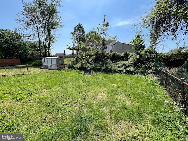 1948 Victory Dr, Baltimore, MD 21227 - view of yard with fence, a storage unit, and an outbuilding