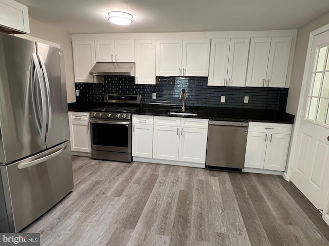 1948 Victory Dr, Baltimore, MD 21227 - kitchen featuring dark countertops, appliances with stainless steel finishes, a sink, decorative backsplash, and under cabinet range hood