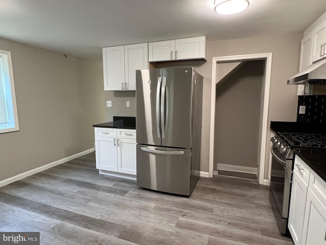 1948 Victory Dr, Baltimore, MD 21227 - kitchen featuring under cabinet range hood, white cabinetry, dark countertops, and appliances with stainless steel finishes