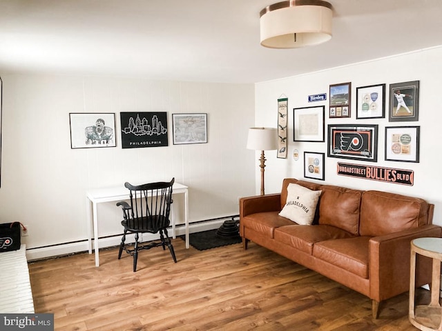 living area with baseboard heating and wood finished floors