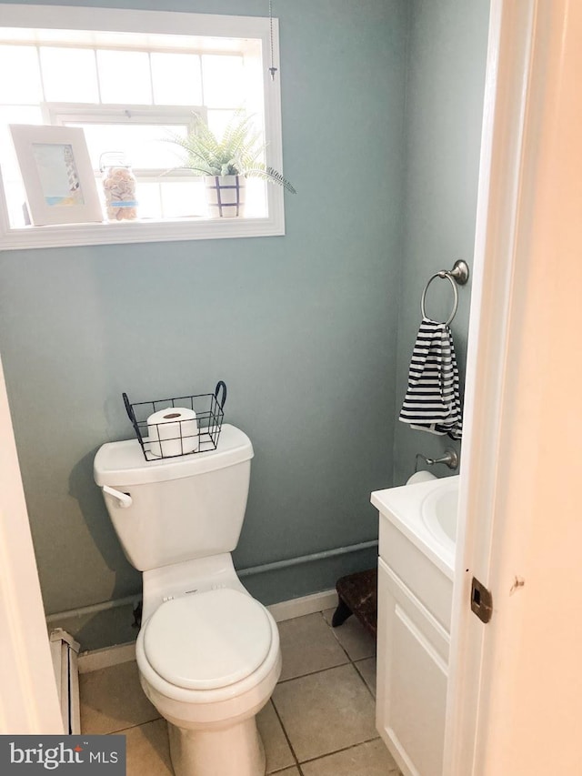 bathroom with baseboards, tile patterned floors, toilet, and vanity