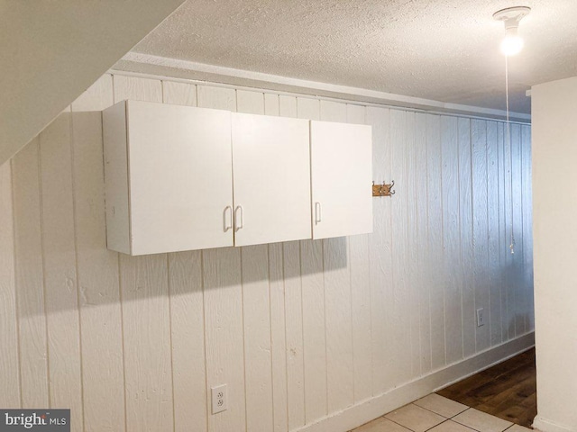 interior details with wooden walls and a textured ceiling