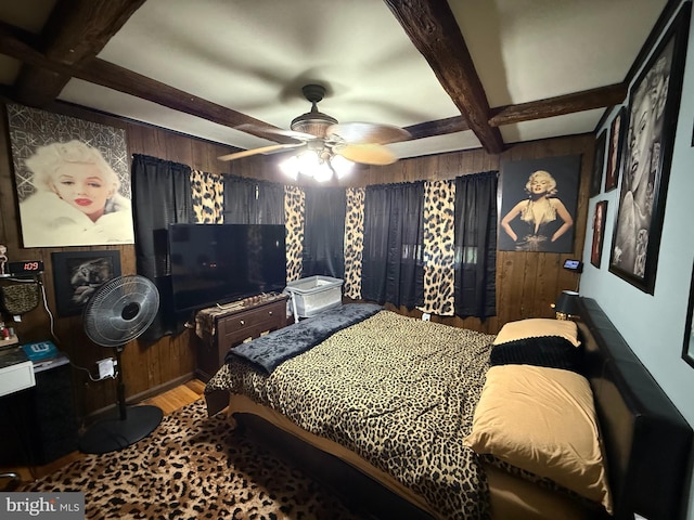 bedroom featuring beam ceiling, coffered ceiling, a ceiling fan, wood walls, and wood finished floors