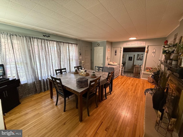 dining room with ornamental molding and light wood-style flooring