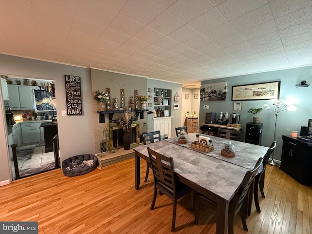 dining space featuring a fireplace and light wood-style floors