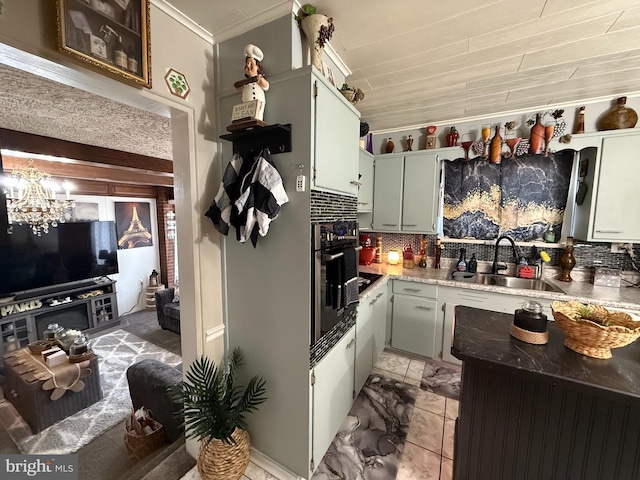 kitchen with decorative backsplash, stainless steel oven, marble finish floor, and a sink