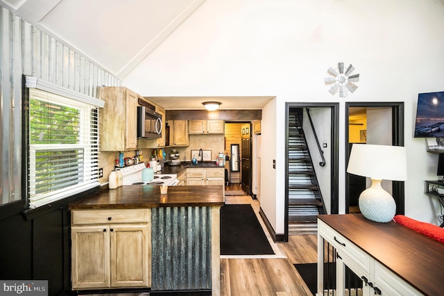 89 Cindys Way, Front Royal, VA 22630 - kitchen with light wood finished floors, a peninsula, stainless steel microwave, backsplash, and vaulted ceiling