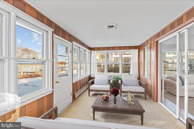 sunroom / solarium featuring carpet and wooden walls