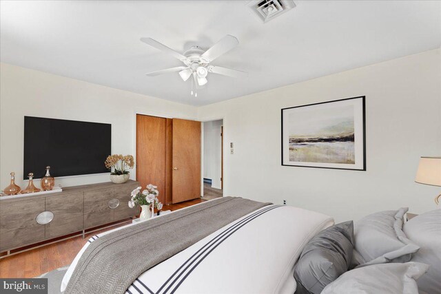 bedroom featuring wood finished floors, visible vents, and a ceiling fan