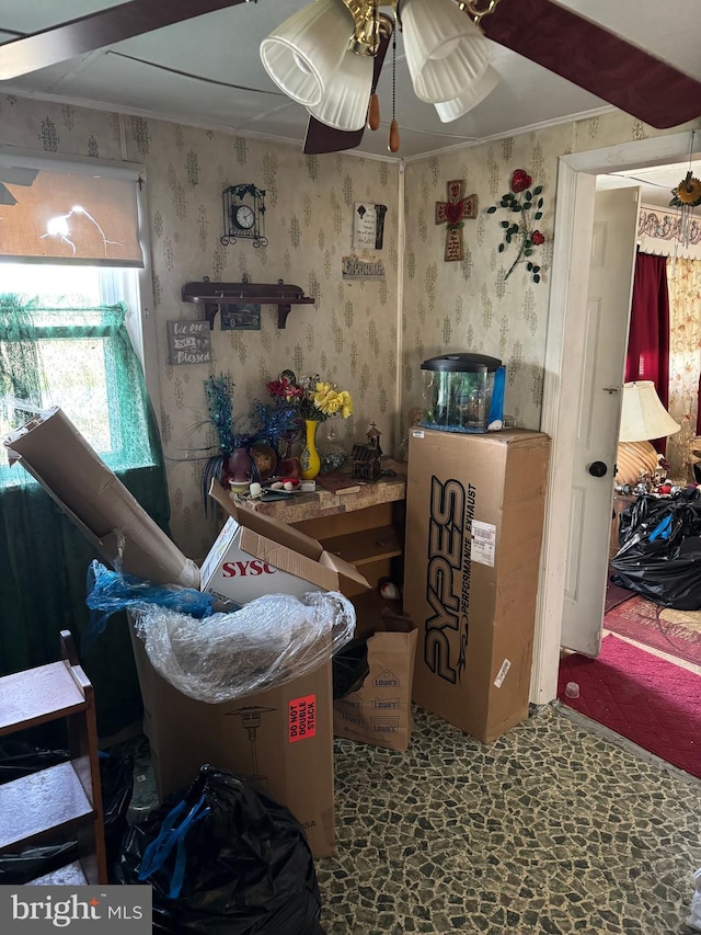 miscellaneous room with stone finish floor, ceiling fan, ornamental molding, and wallpapered walls