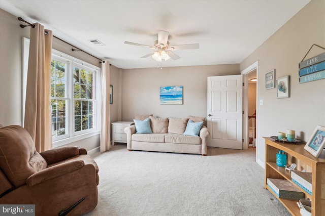 living area featuring visible vents, a ceiling fan, and carpet floors
