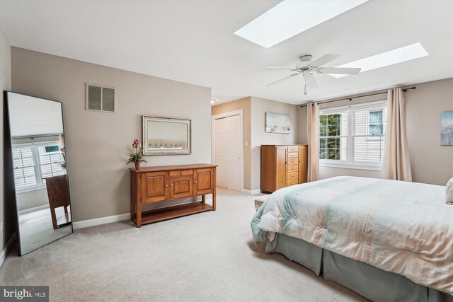 bedroom featuring visible vents, a skylight, multiple windows, and light colored carpet