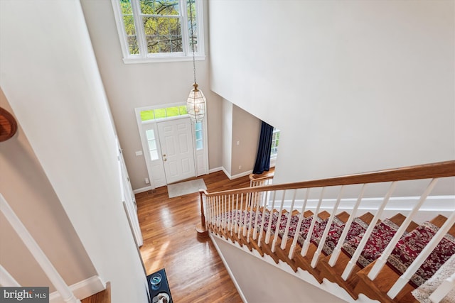 entryway with baseboards, a high ceiling, and light wood-style flooring