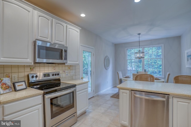 kitchen featuring appliances with stainless steel finishes, decorative backsplash, white cabinetry, light countertops, and recessed lighting