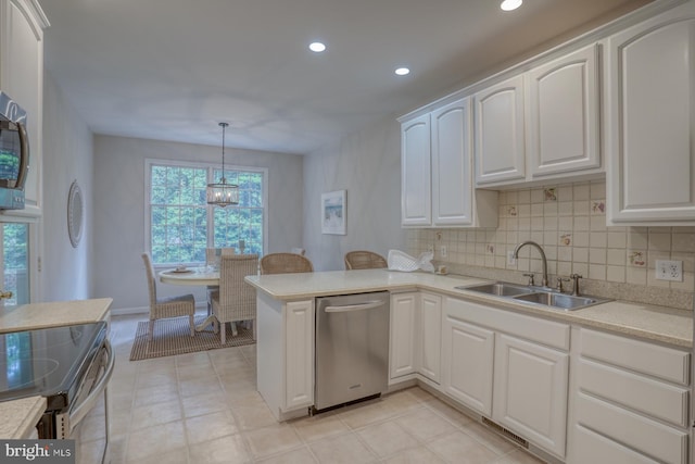 kitchen featuring a sink, stainless steel appliances, recessed lighting, a chandelier, and white cabinets