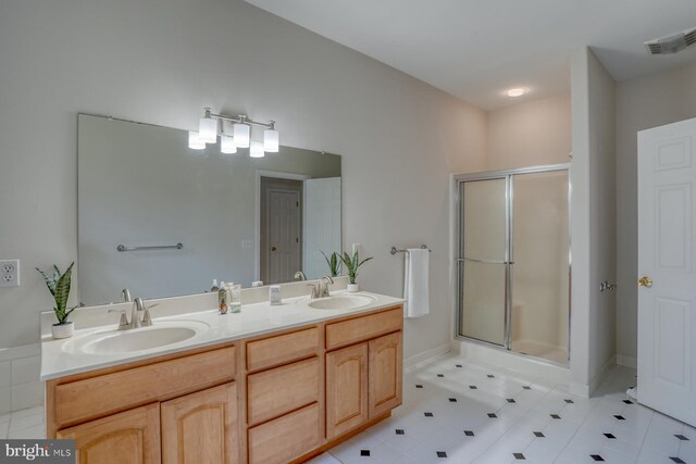 bathroom featuring a stall shower and double vanity