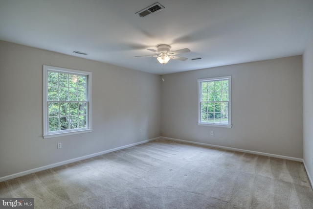 carpeted spare room with ceiling fan and baseboards