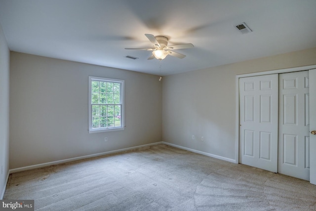 unfurnished bedroom featuring carpet floors, a closet, baseboards, and a ceiling fan