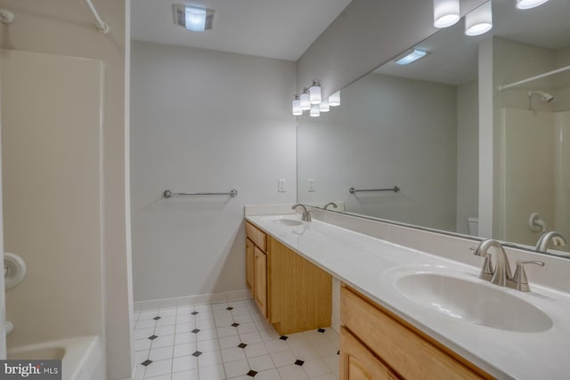 full bathroom featuring a shower, toilet, double vanity, baseboards, and tile patterned floors