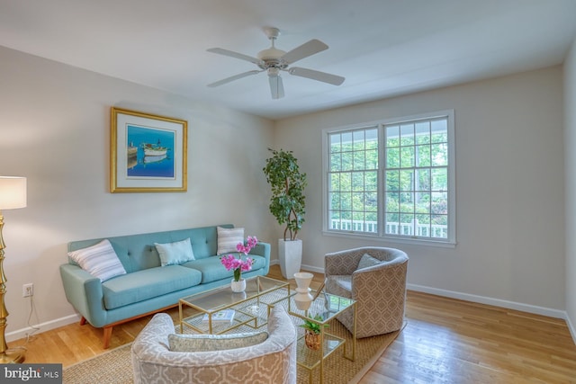 living room with wood finished floors, baseboards, and a ceiling fan