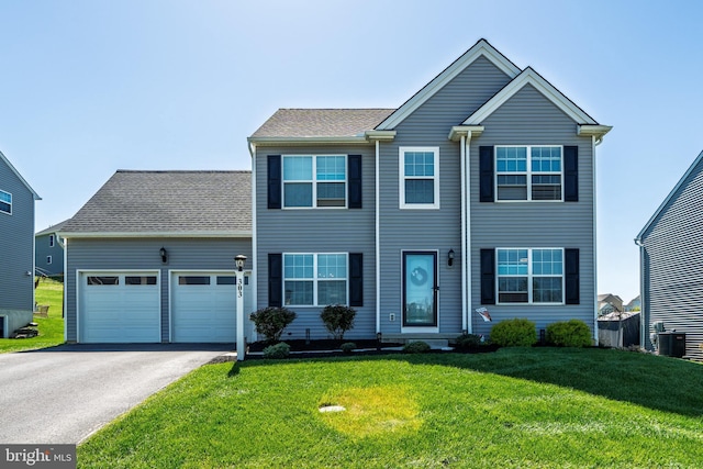 colonial-style house featuring a garage, a front lawn, aphalt driveway, and cooling unit