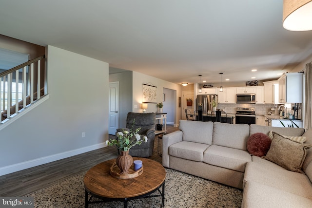 living area with stairway, baseboards, recessed lighting, and dark wood-type flooring