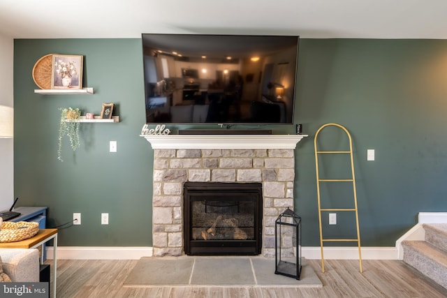 details featuring baseboards, a fireplace, and wood finished floors