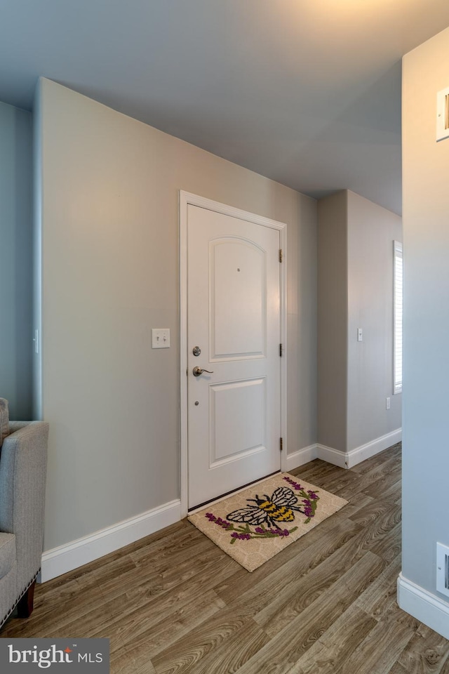 entryway with baseboards, wood finished floors, and visible vents