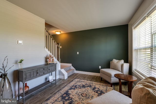living area with stairs, baseboards, and wood finished floors