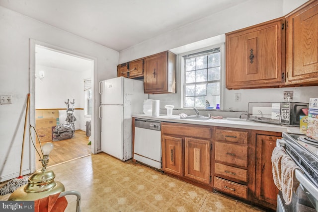 5610 Gallatin Pl, Hyattsville, MD 20781 - kitchen featuring white appliances, a sink, brown cabinetry, light countertops, and light flooring