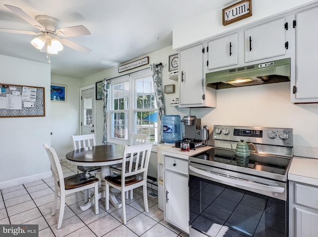 kitchen featuring a ceiling fan, stainless steel range with electric cooktop, light countertops, light tile patterned floors, and under cabinet range hood