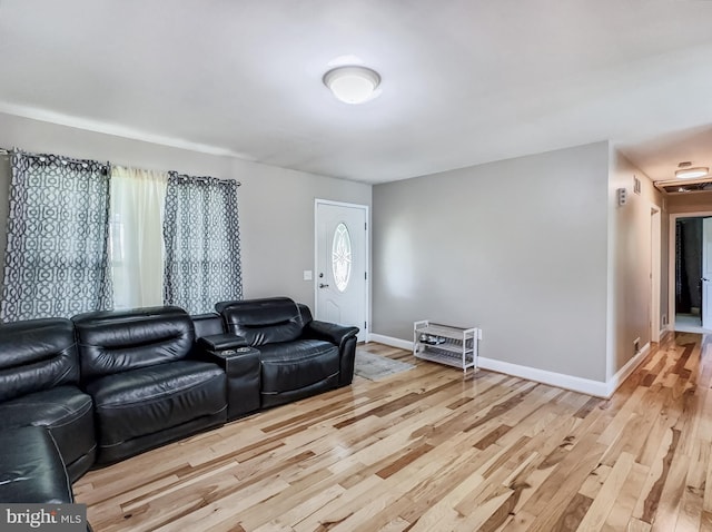 living area featuring baseboards and light wood-style flooring