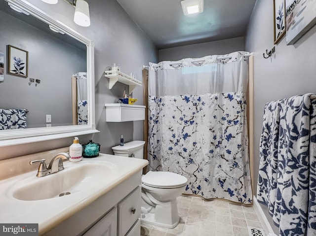 bathroom featuring toilet, a shower with shower curtain, and vanity