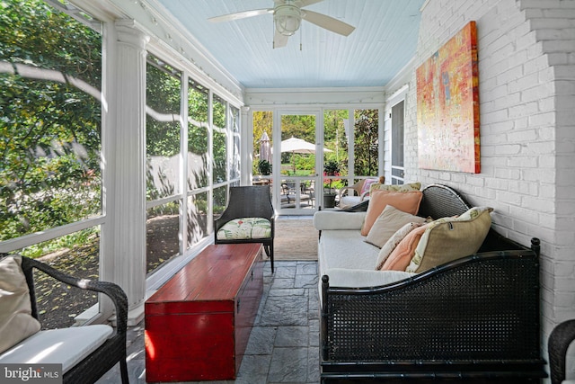 sunroom / solarium featuring a ceiling fan and an outdoor living space