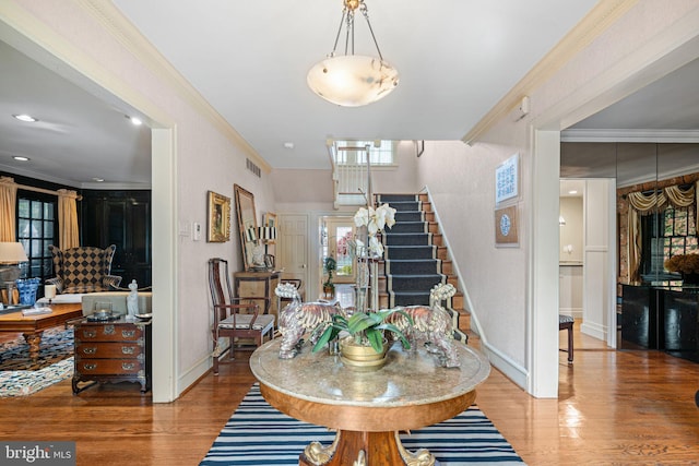 dining space with wood finished floors, stairs, baseboards, and crown molding