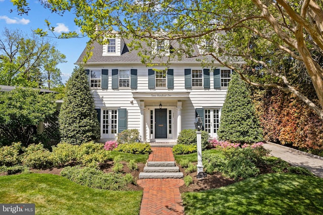 colonial-style house featuring a front yard
