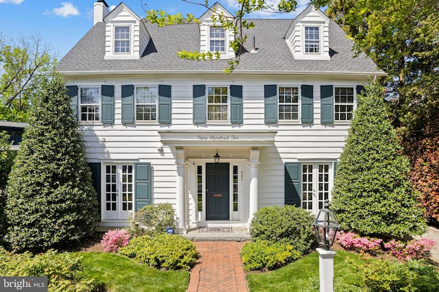 view of front of house with a chimney and roof with shingles