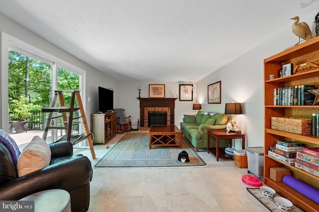 living area featuring a brick fireplace and a textured ceiling