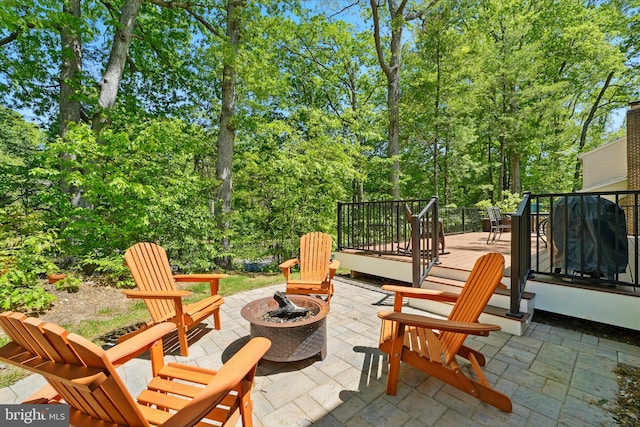 view of patio / terrace with an outdoor fire pit and a wooden deck
