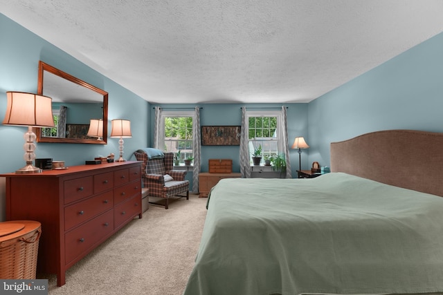 bedroom with a textured ceiling and light colored carpet