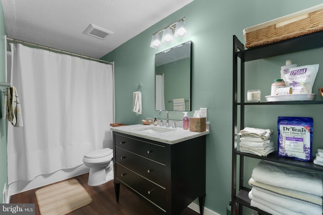 full bath featuring visible vents, vanity, wood finished floors, toilet, and shower / bath combo