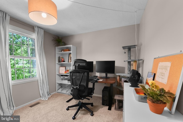 carpeted home office featuring baseboards, a textured ceiling, and visible vents